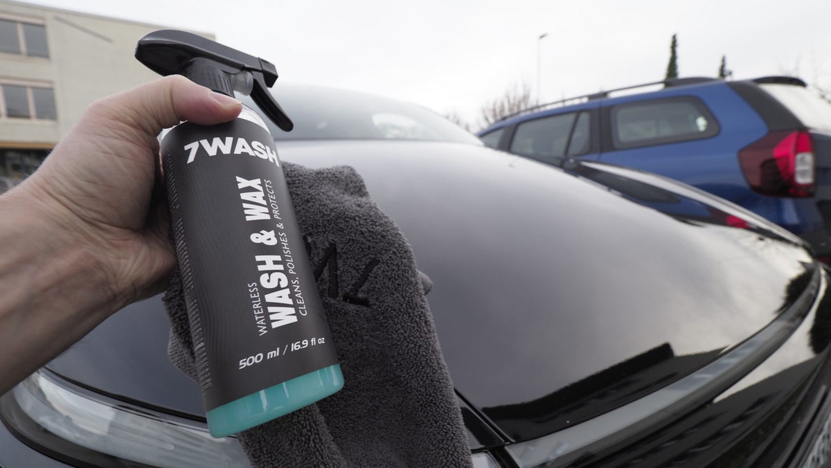 7WASH Wash & Wax Waterless Sprühflasche und Mikrofasertuch über einer schwarzen Motorhaube