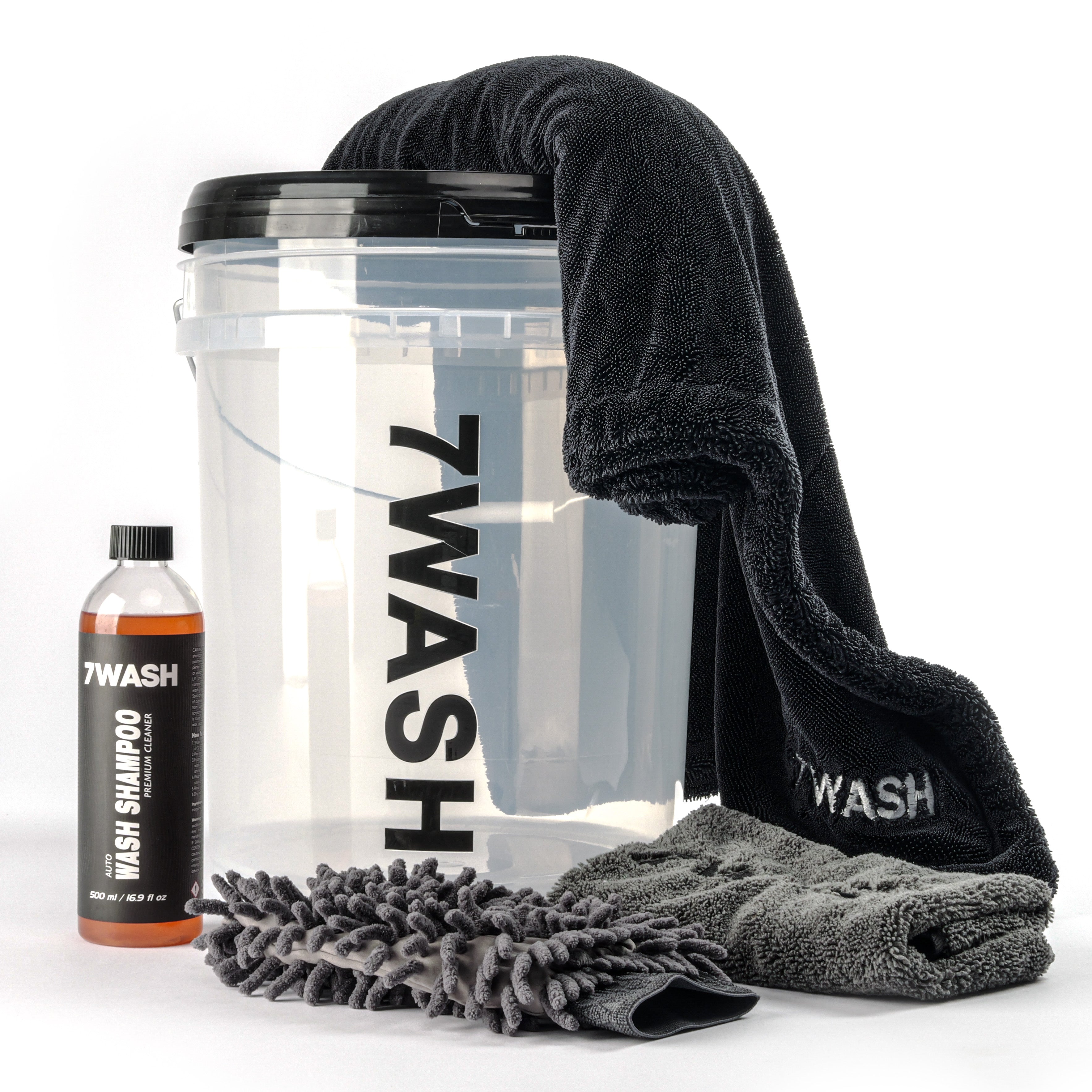 7WASH Starter Wash Set bestehend aus einem transparenten Wascheimer mit schwarzem Logo, einer 500ml Flasche Autoshampoo, einem grauen Mikrofaser-Waschhandschuh, einem grauen Trockentuch und einem schwarzen Mikrofasertuch.